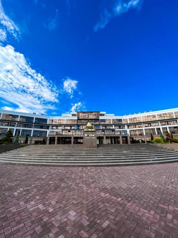 a large building with stairs and a blue sky at Baytur Resort таунхаус in Bosteri