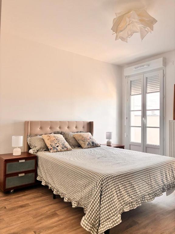 a white bedroom with a bed and a window at 3 pièces proche Disney in Serris