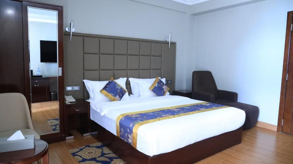 a bedroom with a large bed and a mirror at Nile View Hotels in Bahir Dar