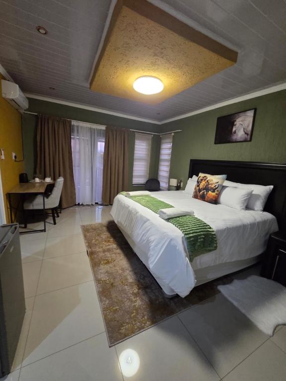 a bedroom with a large bed and a table at RIER Guesthouse in Pretoria