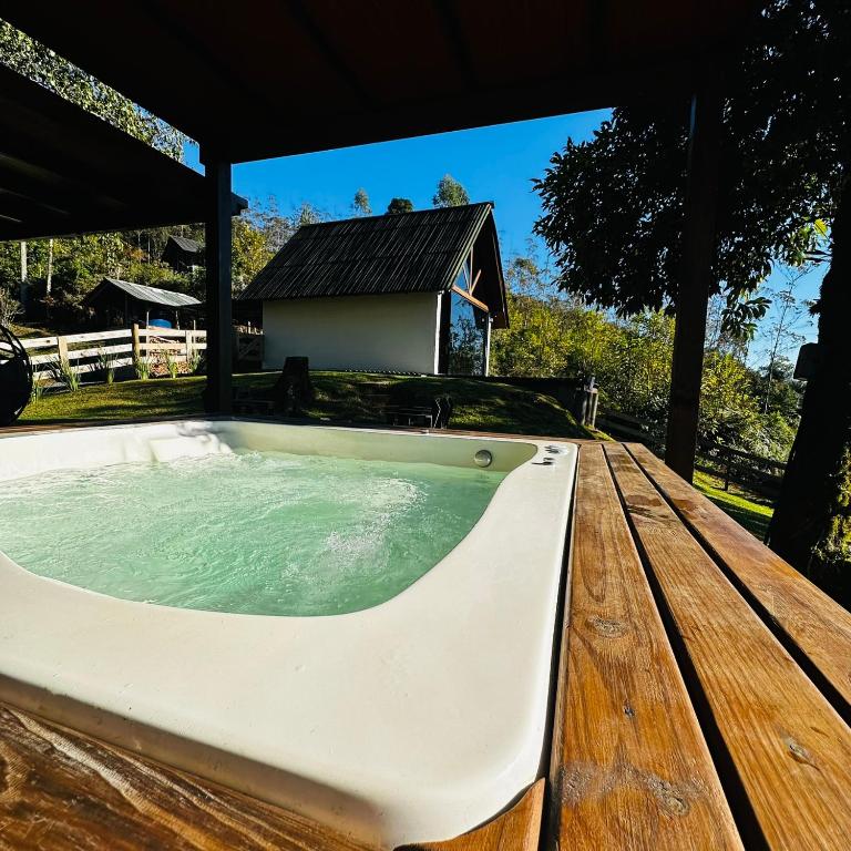 a jacuzzi tub on a wooden table at Chalé Brisa Verde in Rio dos Cedros