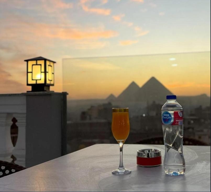 a bottle of water and a glass of wine on a table at Pyramids Giza inn in Cairo