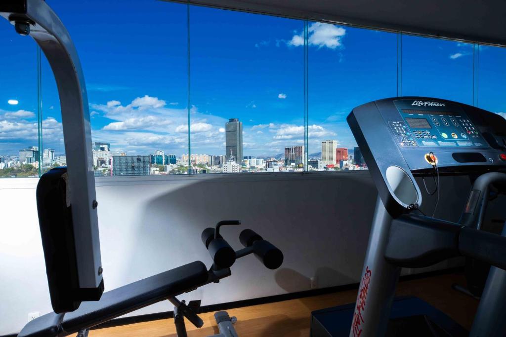 A cardio and strength-training corner overlooking Mexico City's skyline.