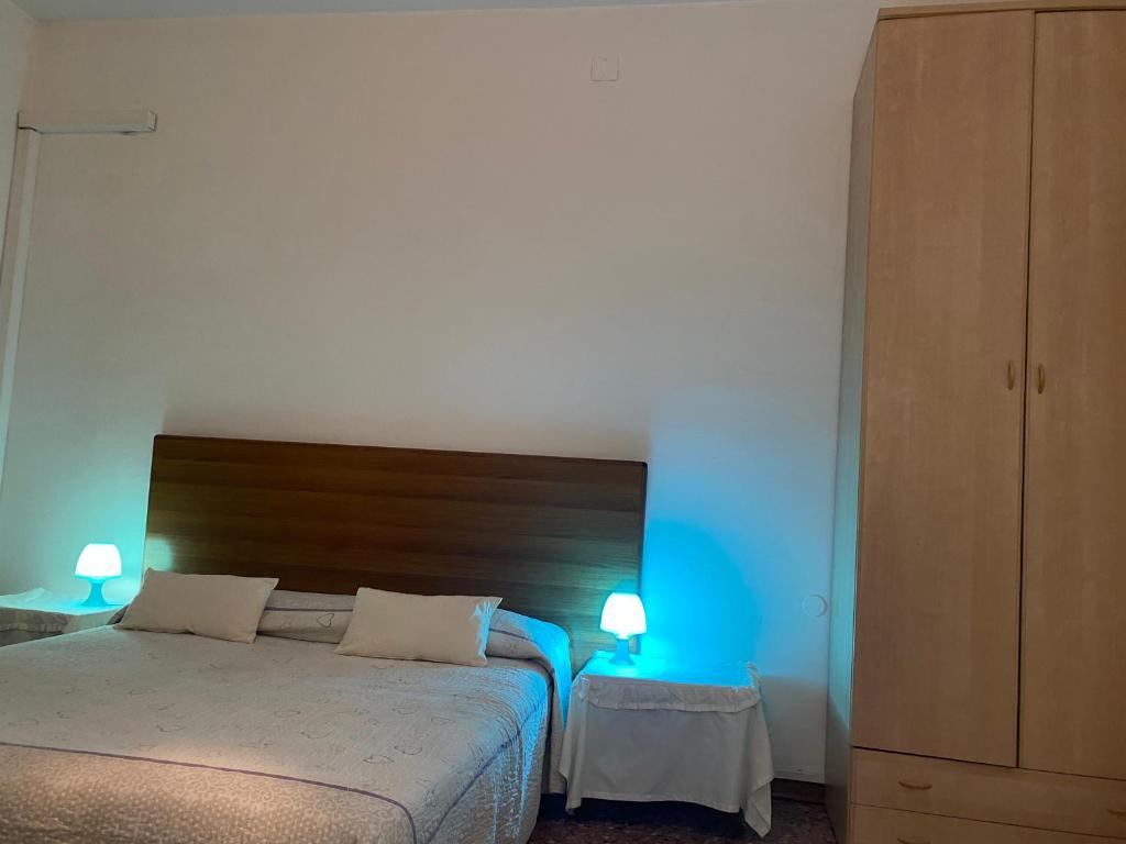 a bedroom with a bed with blue lights on it at Travellers Lodge Bed & Rooms in Treviso