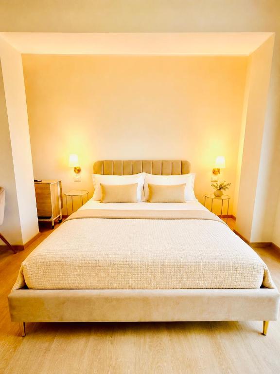 a bedroom with a large bed with two lamps at Le Charme Luxury Suite in Patti