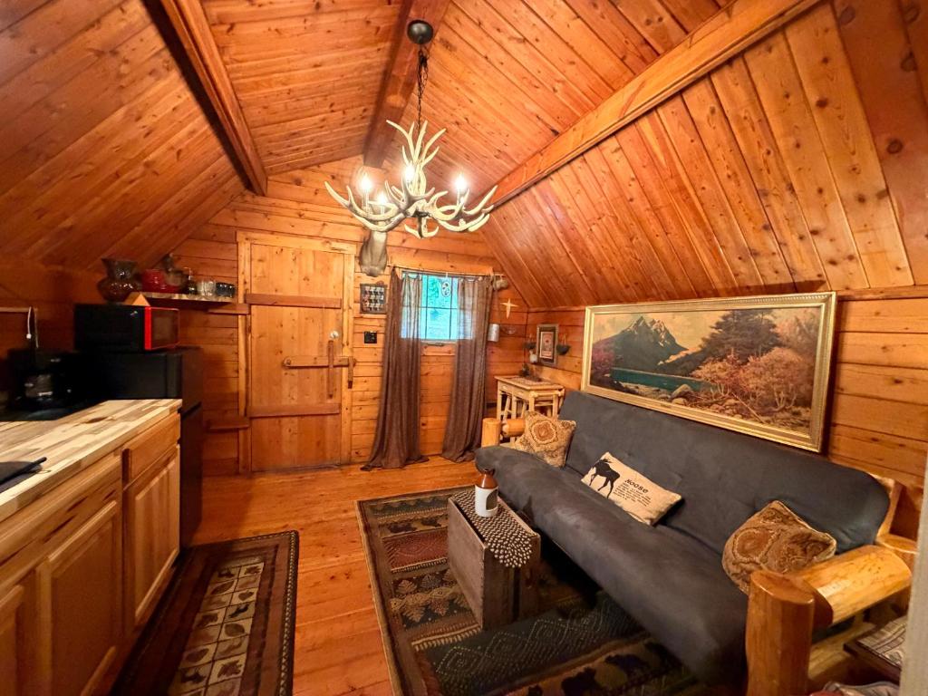 a living room with a couch in a cabin at The Dapper Duck Log Cabin in Cosby