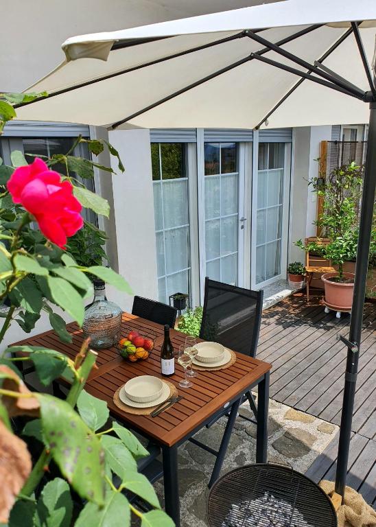 a wooden table with a bottle of wine on a patio at Apartma Tomažič in Hrušica
