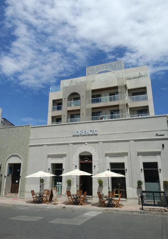a building with tables and umbrellas in front of it at Joy Tower by FMA Coliving in Salta