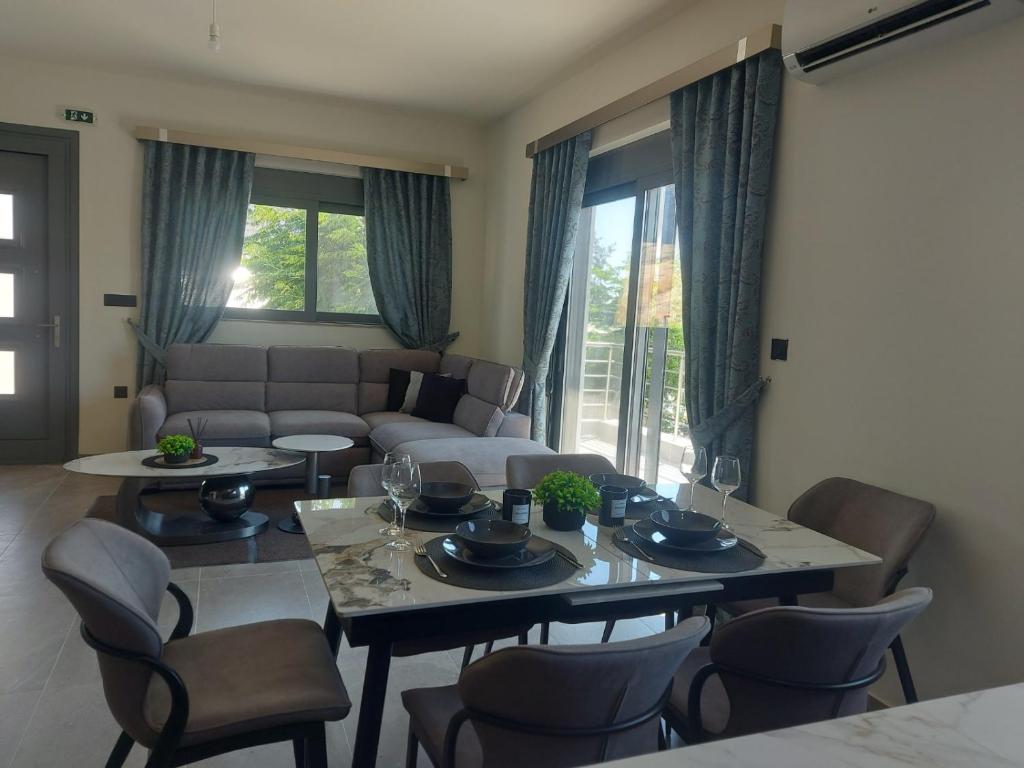 a living room with a table and chairs and a couch at Dani & Fani suite in Afantou