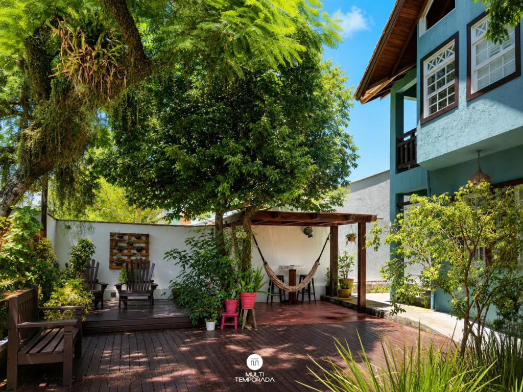 a patio in front of a house with a tree at Pousada Solar das Pétalas - Florianópolis/SC in Florianópolis