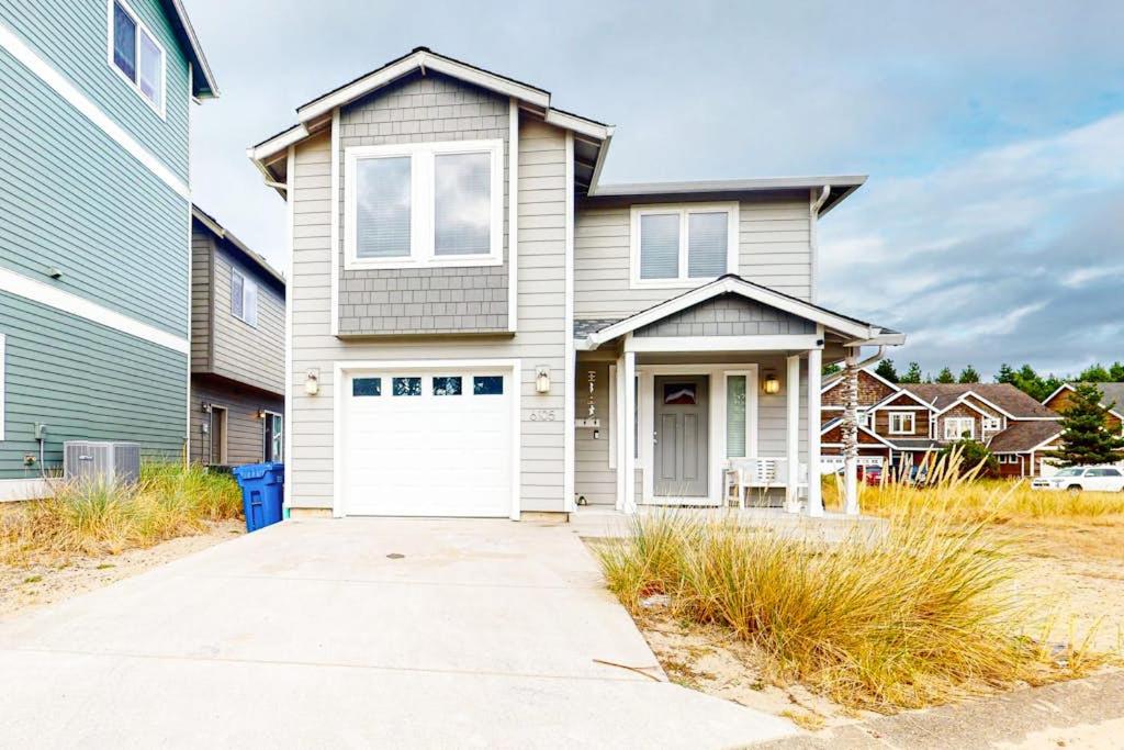 a house with a white garage door in a yard at Dory Pointe Dream in Pacific City