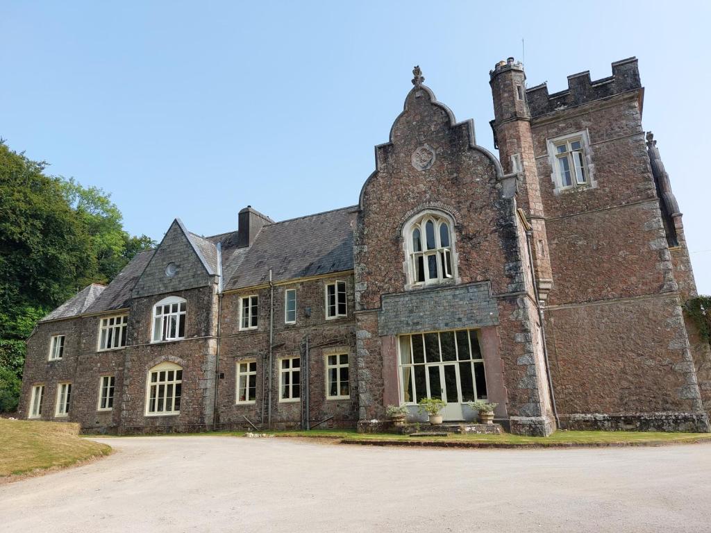 an old brick building with a clock on it at Lukesland Wing in Ivybridge