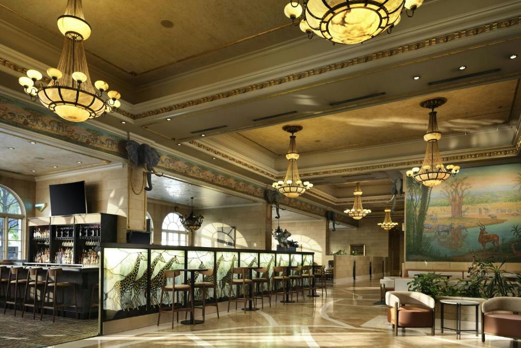 a lobby with a bar and chairs and chandeliers at The Davenport Tower, Autograph Collection in Spokane