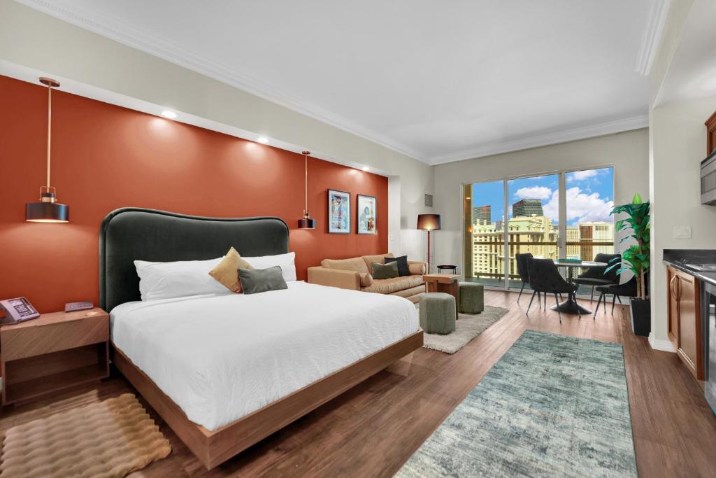 a bedroom with a bed and a living room at Luma Vera Penthouse Sanctuary Strip Views in Las Vegas