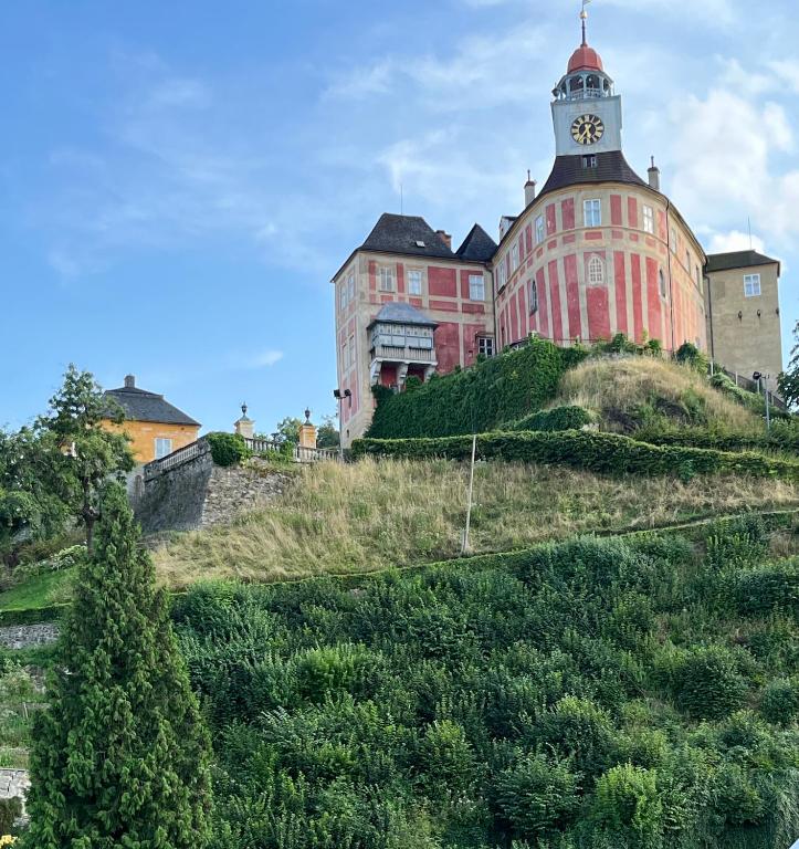 a building with a clock tower on top of a hill at Apartmán Pod Jánským Vrchem in Javorník