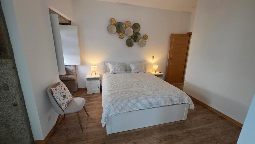 a bedroom with a white bed and a chair at In Viana in Viana do Castelo