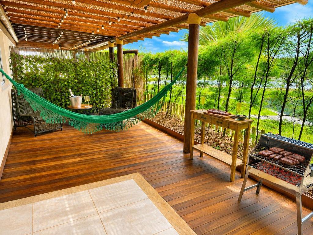 a patio with a hammock on a wooden deck at Village Baixio Garden in Baixio