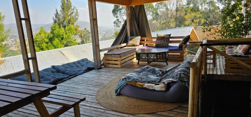 a porch with a couch and a table on a deck at Wood & Net in Iringa
