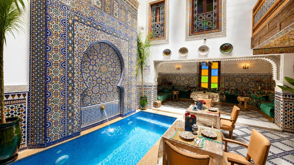 a room with a swimming pool and a tile wall at Riad Dar ElBellar in Fez