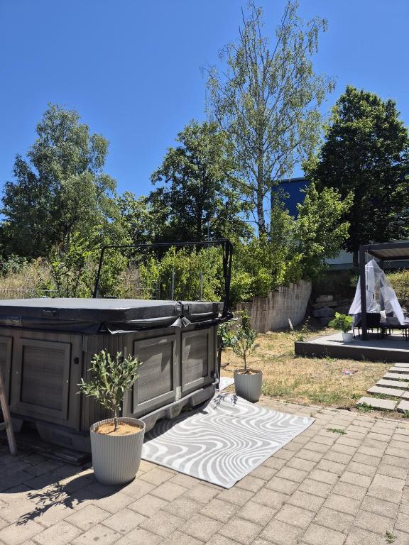 eine Terrasse mit zwei Topfpflanzen und einem Whirlpool in der Unterkunft Big Loft in Empfingen