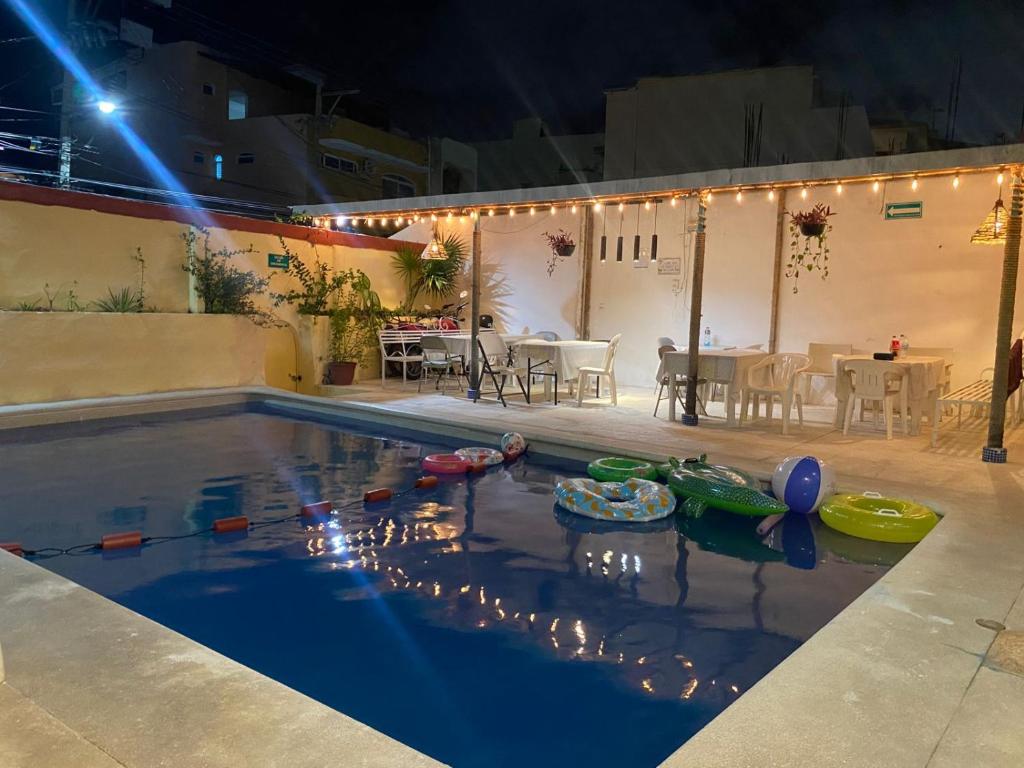 a swimming pool with boats in the water at night at Hotel Bora Bora Acapulco in Acapulco