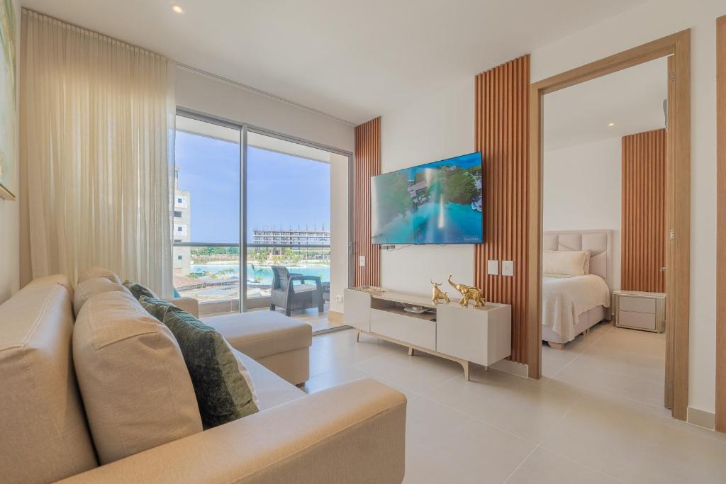 a living room with a couch and a bed and a television at BaiaKristal-Kabo3-3A in Cartagena de Indias