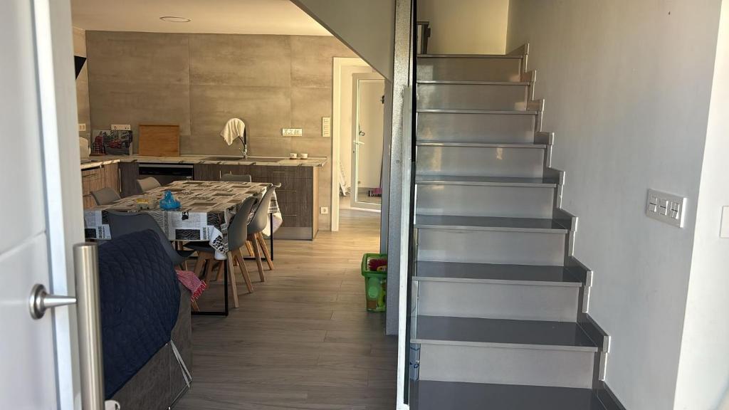 a stairway in a room with a kitchen and a table at Villa HEGODEI in A Pobra do Caramiñal