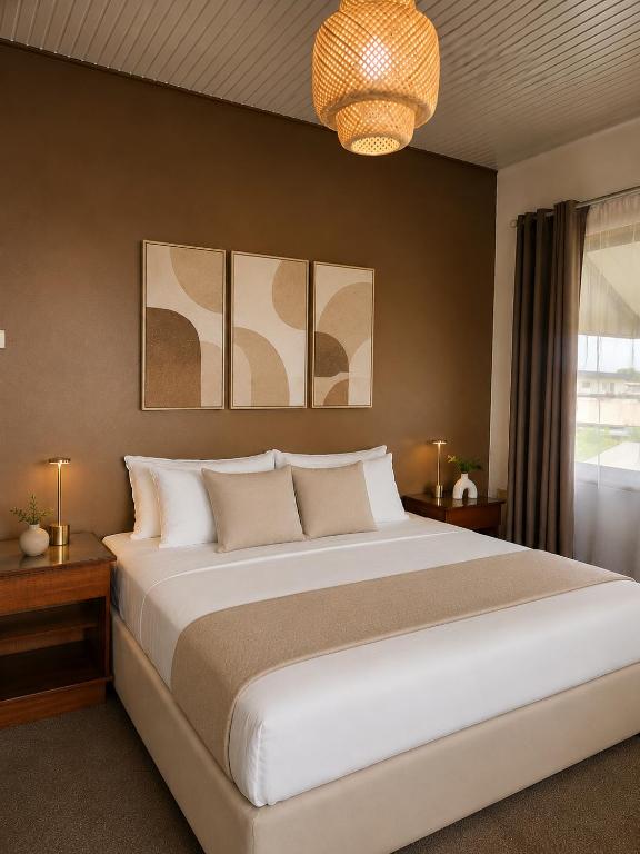 a bedroom with a large bed and a chandelier at Tropical Breeze Apartments in Paramaribo