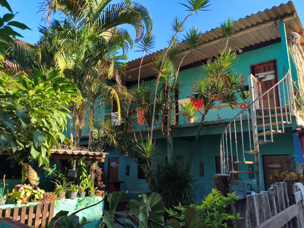 a house with palm trees in front of it at Pousada Suíte Conexao in Conceição da Barra