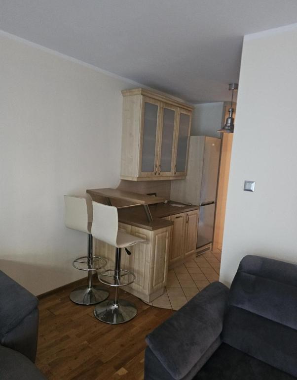 a living room with a kitchen and a table at Apartament Merkury in Koszalin