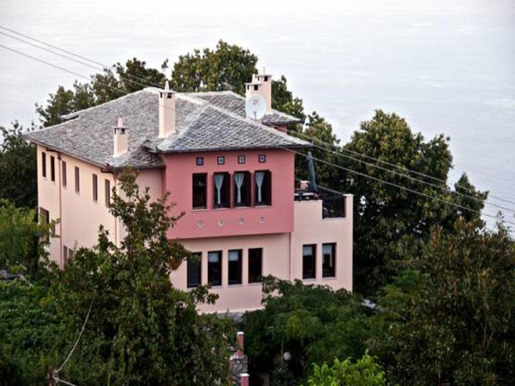 une maison rose assise au sommet d'une colline dans l'établissement Villa Aglaini, à Ágios Dimítrios