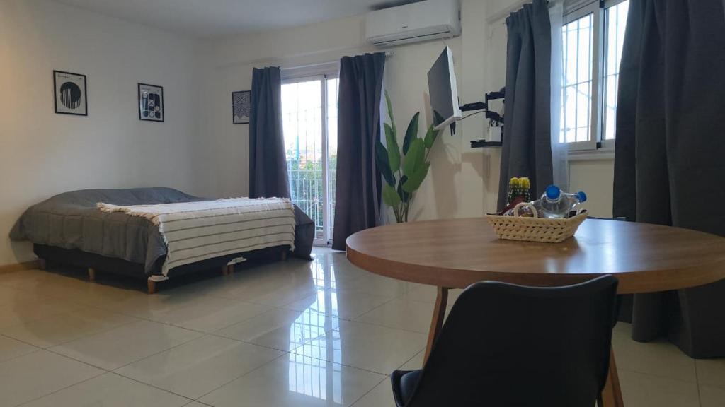 a bedroom with a table and a bed and a table and chairs at Apart Plaza Escobar in Belén de Escobar