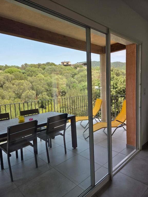 a dining room with a table and chairs on a balcony at Sarl Valinco Locations in Olmeto
