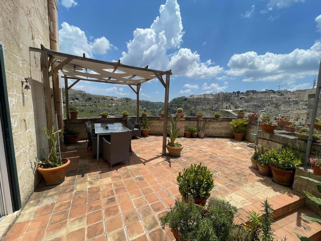 a patio with a table and potted plants at Corte dei Venti in Matera
