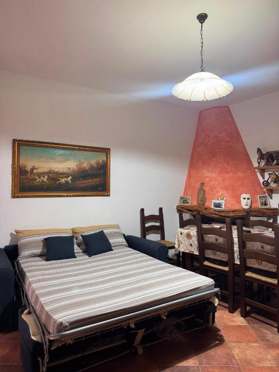 ein Schlafzimmer mit einem Bett, einem Tisch und einer Lampe in der Unterkunft Maison Marcel in Galtellì