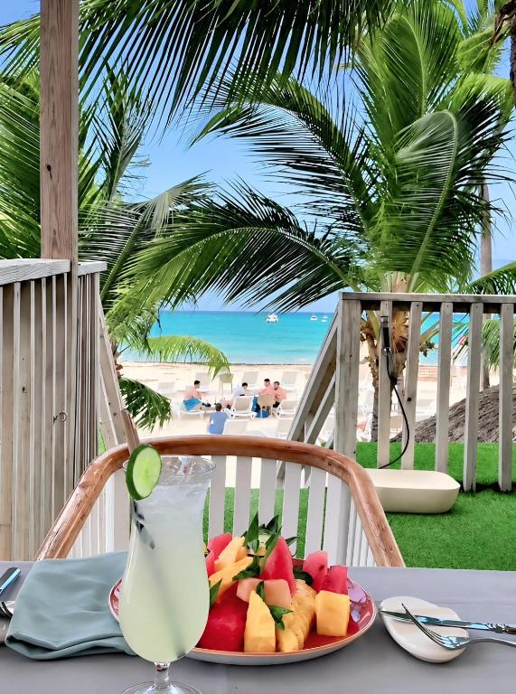 a plate of fruit on a table with a drink at Hotel Bloom Garden Beach Punta Cana in Punta Cana