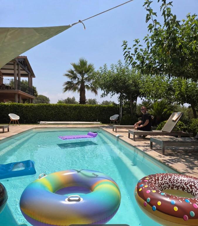 a man sitting on a bench in a swimming pool at sci marie dominique in Olmeto