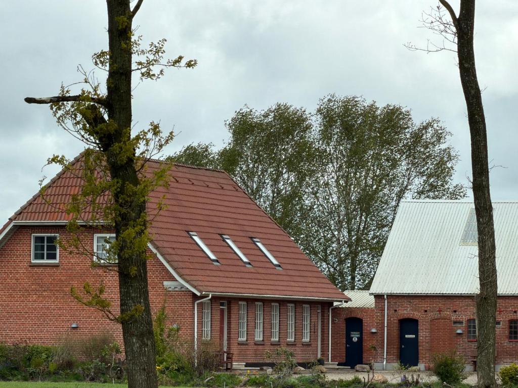 a red brick building with a red roof at Vestergård Gæstehus in Varde