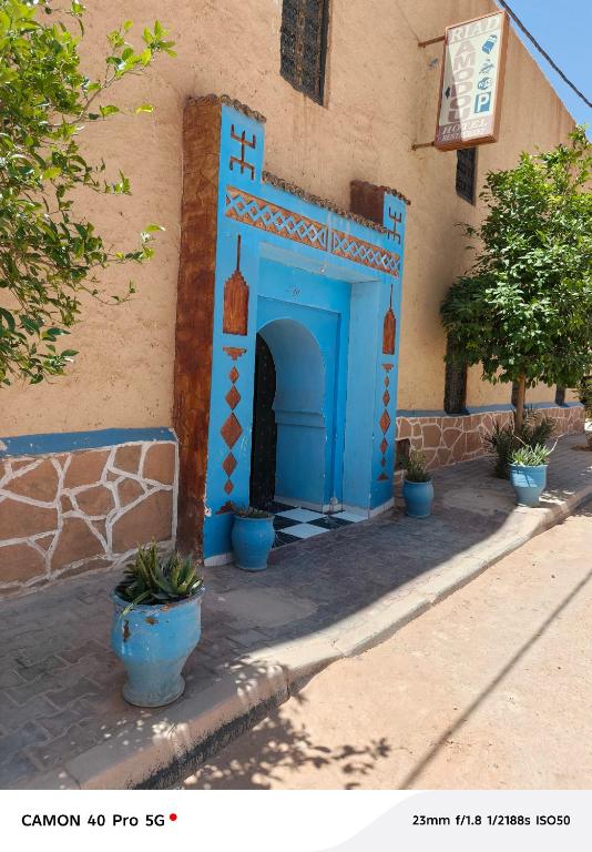 a building with a blue door on the side of it at Hostel amodou in Tinerhir