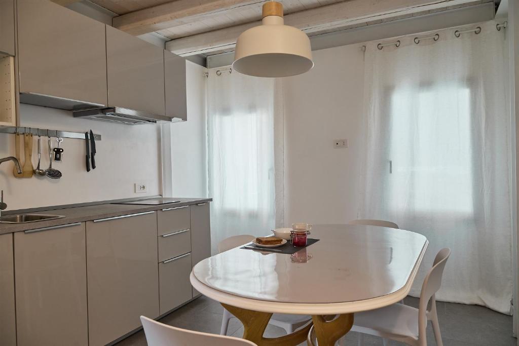 a white kitchen with a white table and chairs at Sottomarina Suite Palazzo Storico in Chioggia