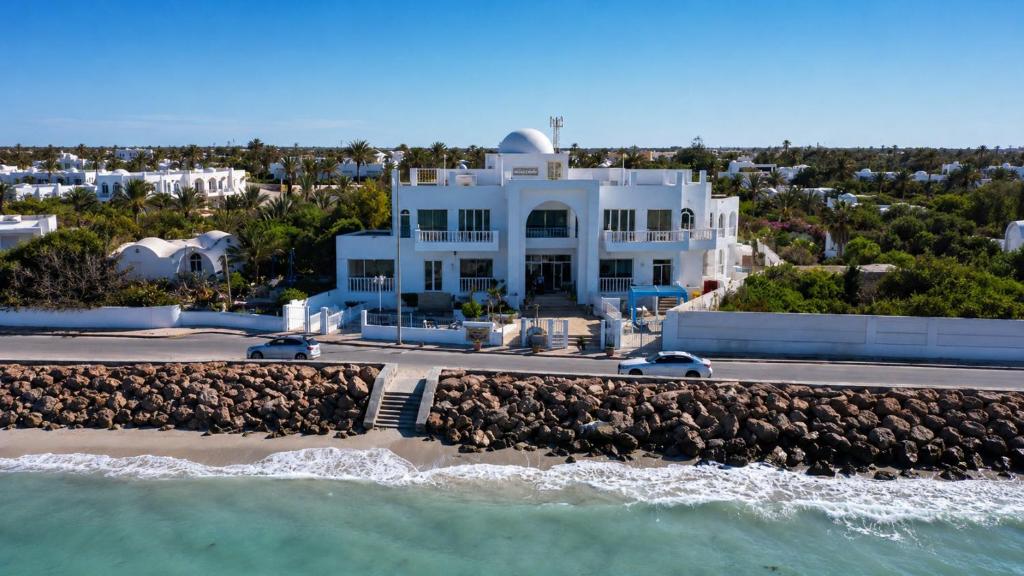 an aerial view of a white house on the beach at Hotel FLAMINGO BEACH in Djerba