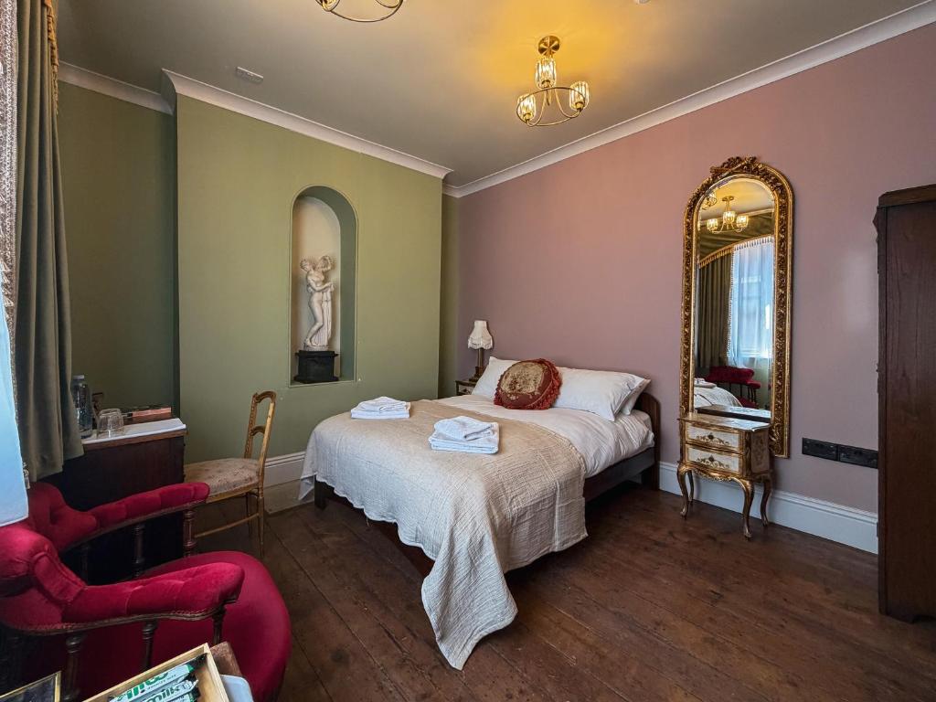 a bedroom with a bed and a mirror and a chair at 41 Whitfield Street Hotel in London