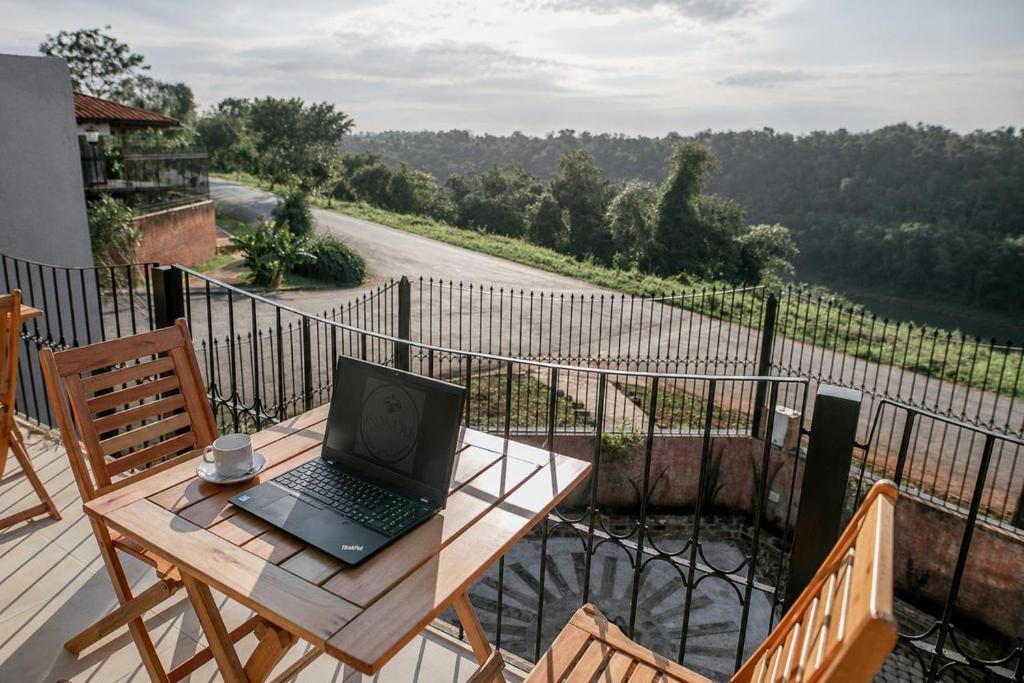 a laptop computer sitting on a wooden table on a balcony at ISONDU Suites & Breakfast in Puerto Iguazú
