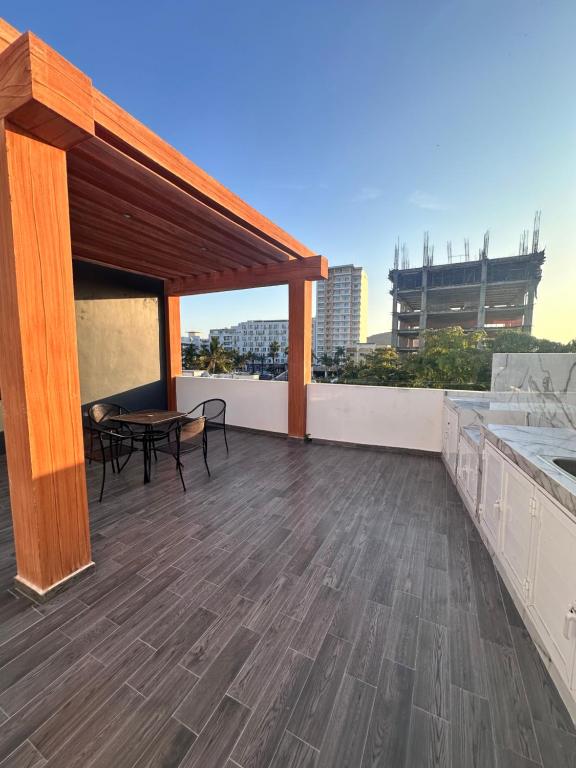 a patio with a table and chairs on a roof at Torre Monaco en Sabalo Country in Mazatlán