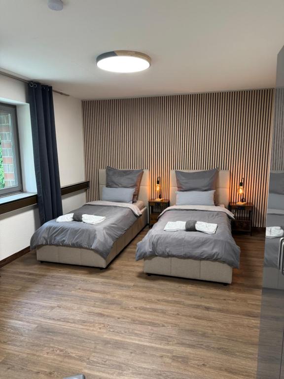 a bedroom with two beds and two lamps on the floor at Garland-Rooms in Bremen