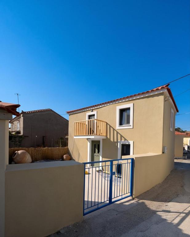 a house with a blue gate in front of it at Lithos Heritage in Líkhna