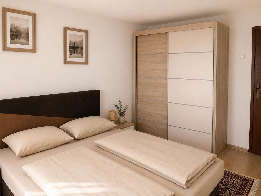 a bedroom with a bed with a wooden closet at Apartmani Natura SH in Hodžinac