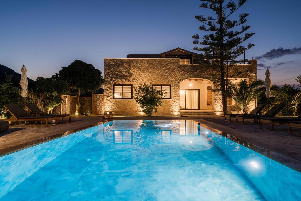 a swimming pool in front of a house at Jacomo Private Villa in Alykes