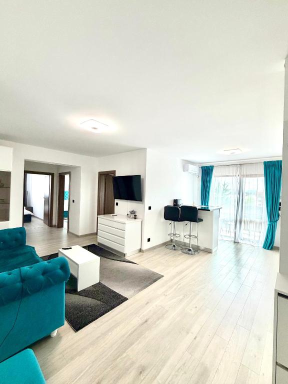 a living room with a blue couch and a tv at Blue Apartment with Free Parking&Self Check-in in Bistriţa