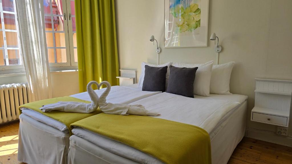 ein Schlafzimmer mit einem Bett, auf dem ein Handtuchtier liegt in der Unterkunft Hotel Emma in Östersund